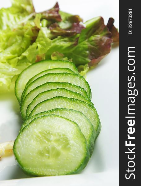 Cucumbers on plate with green salad. selective focus