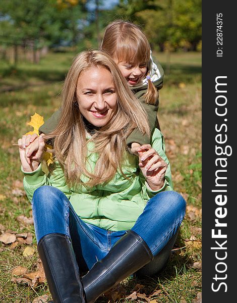 Young mother and her toddler girl in autumn