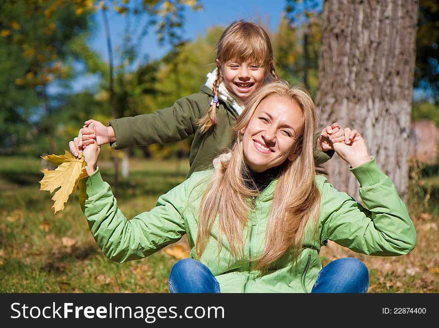 Young mother and her toddler girl in autumn fields