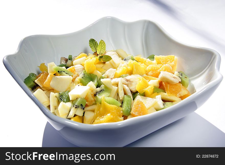 Mixed fruit salad with orange , kiwi , apple , banana , pear and ornamental mint leaves