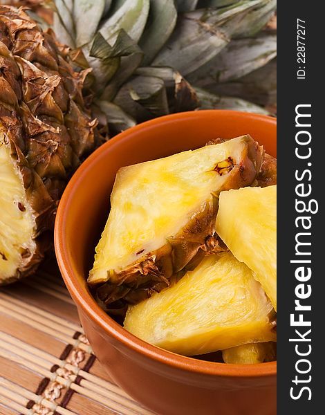 Pineapple chunks in a brown bowl