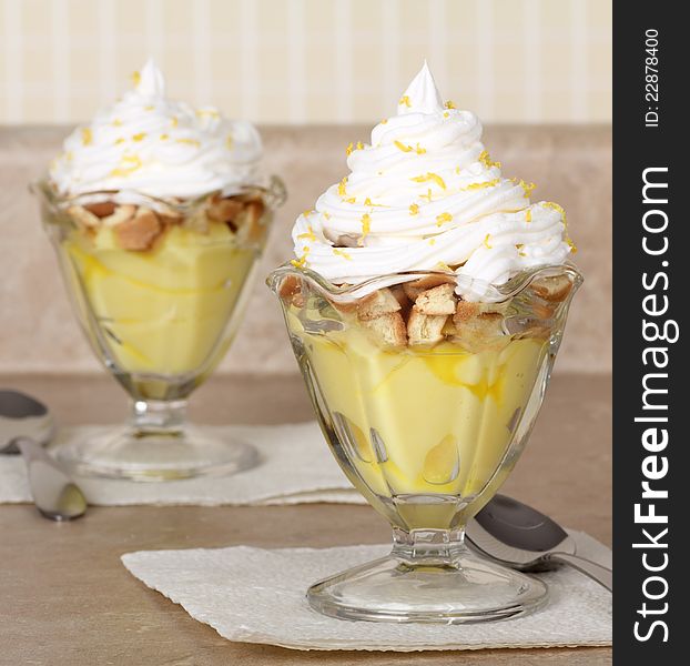 Lemon pudding with whipped cream in glass bowls. Lemon pudding with whipped cream in glass bowls