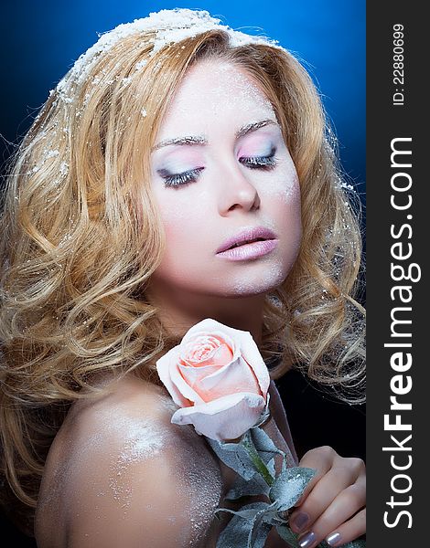 The beautiful blond girl with winter cosmetics and a rose
