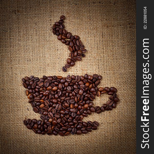 Coffee cup made from beans on burlap background