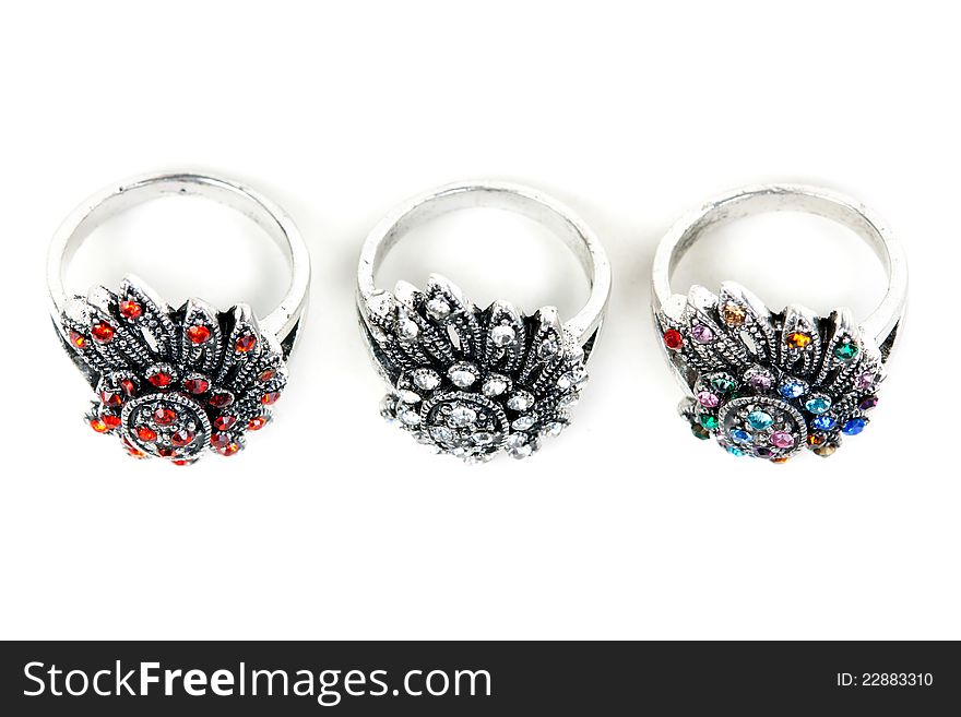 Three silver rings with precious stones on a white background