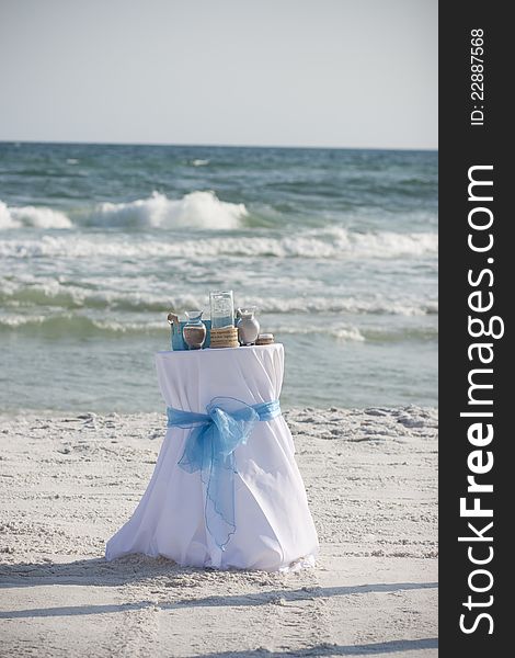 Horizontal photograph of a table used during a wedding ceremony on the beach. Horizontal photograph of a table used during a wedding ceremony on the beach