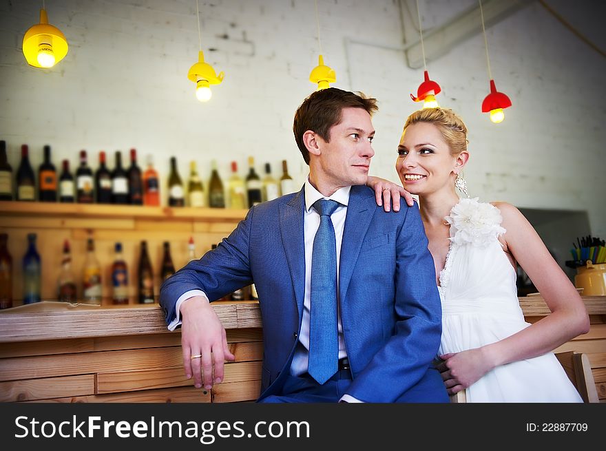 Bride and groom around the bar in the cafe