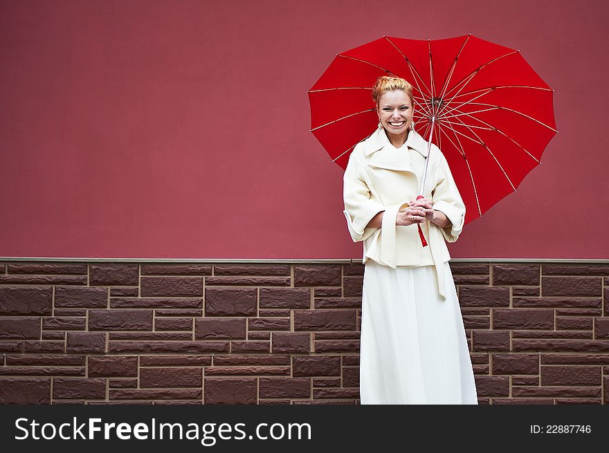 Woman in white coat with red umbrella