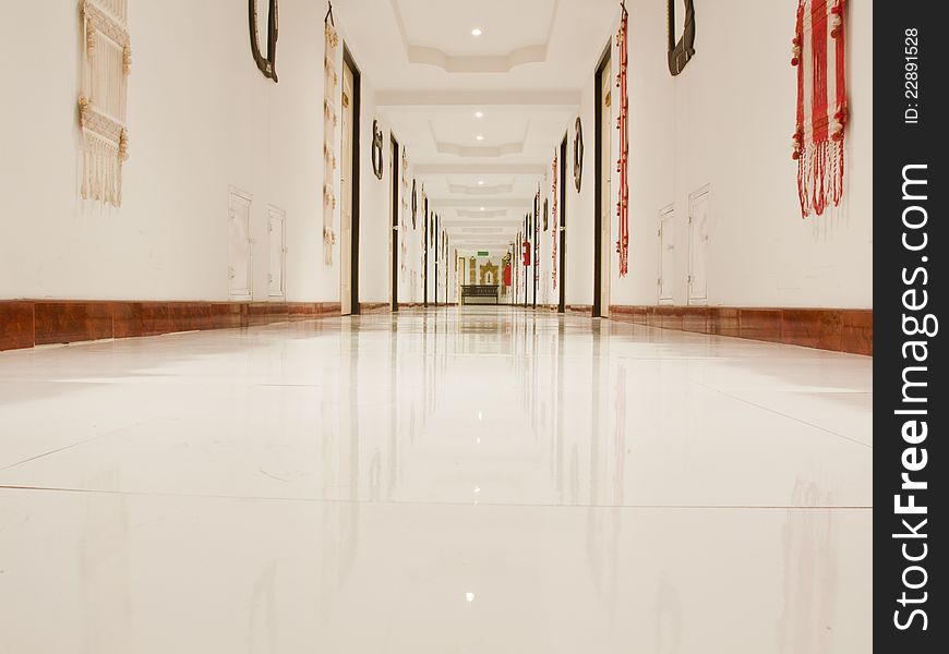 Corridor with white ceiling and reflect white floor in low angle