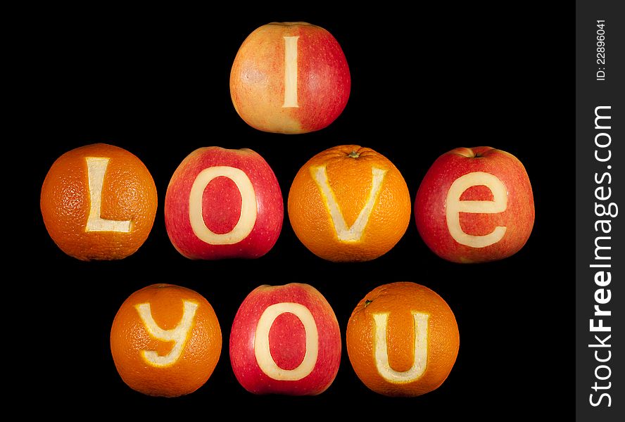 Declaration of love carved on apples and oranges isolated on black. Declaration of love carved on apples and oranges isolated on black