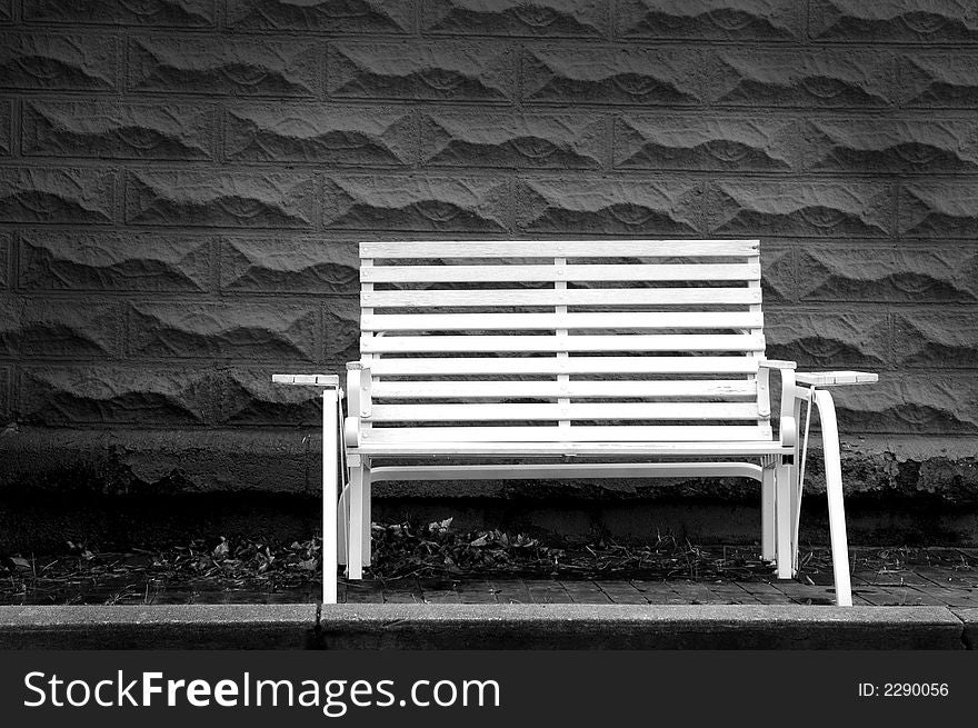 White park bench with gray brick background