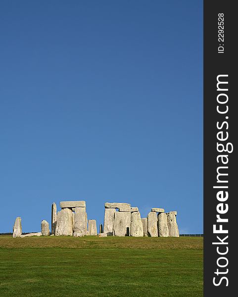 Ancient Stonehenge in England under a clear blue sky