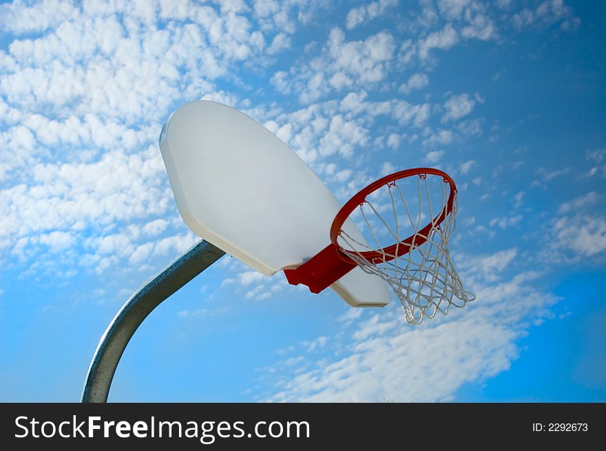 Basketball hoop against blue sky from low angle