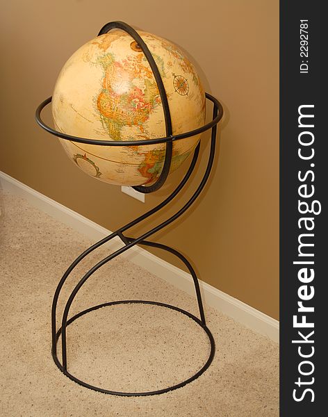 An antique world globe on iron stand