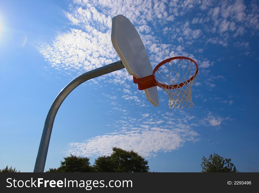 Basketball hoop against blue sky from low angle. Basketball hoop against blue sky from low angle