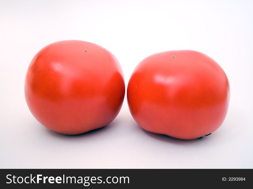 Two red tomatos over white background, macrophotography. Two red tomatos over white background, macrophotography