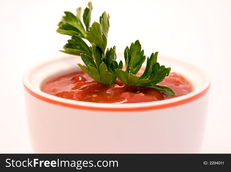 Ketchup with parsley twig and over white background