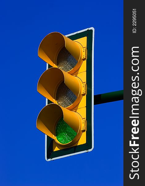 Green traffic light on blue sky