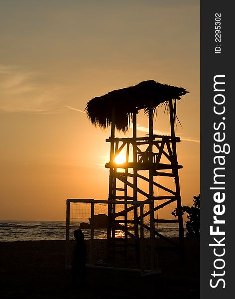 Silhouette of a beach lifeguard tower during sunset
