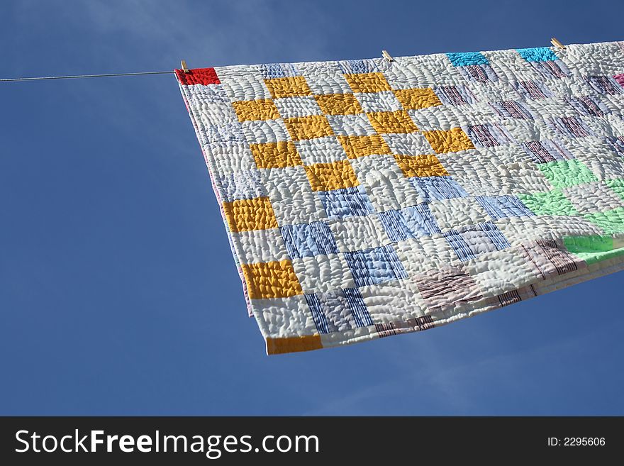 Laundry - bright counterpane hanging to dry on a clothes-line.