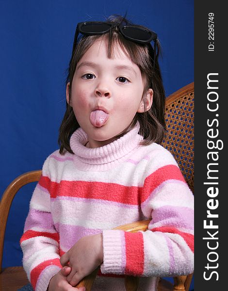 A little girl sticks out her tongue at the camera. A little girl sticks out her tongue at the camera.
