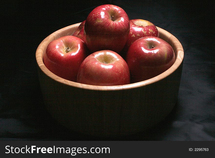 A bowl of healthy apples in low key lighting. A bowl of healthy apples in low key lighting.