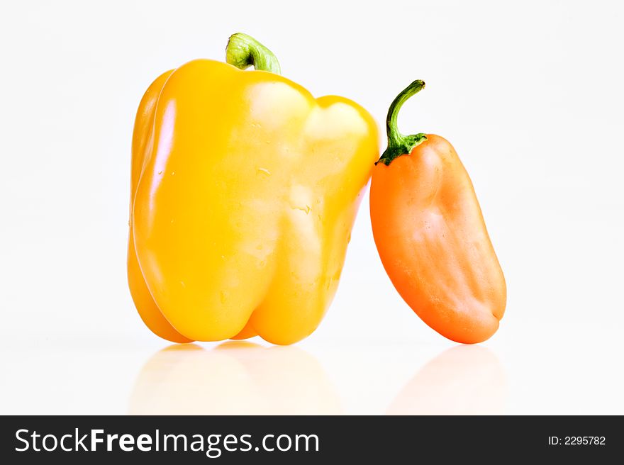 Bell pepper next to a small pepper. Bell pepper next to a small pepper