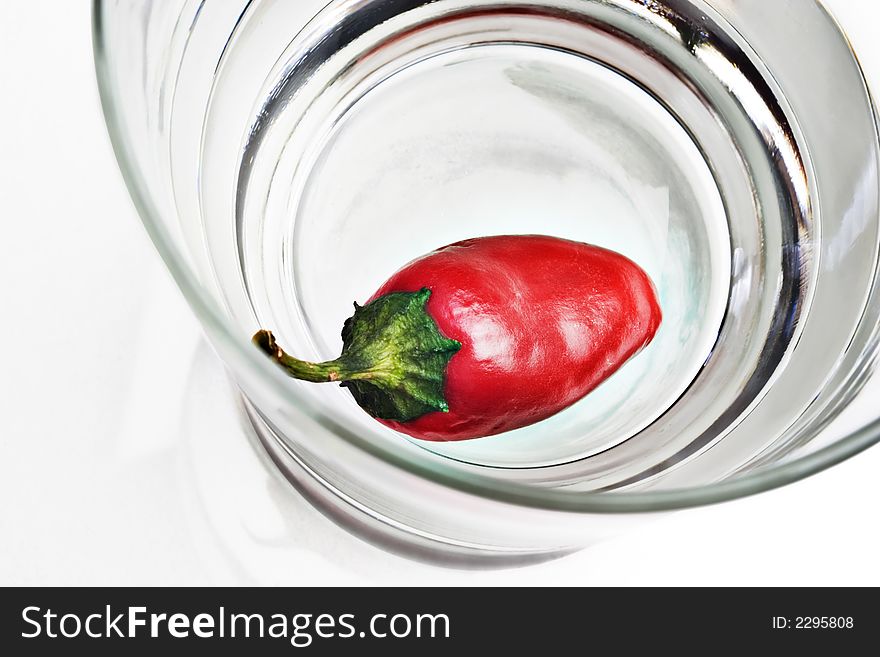 Red pepper in a glass on white