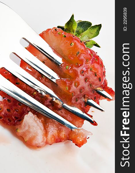 Strawberry being smashed by a fork. Strawberry being smashed by a fork