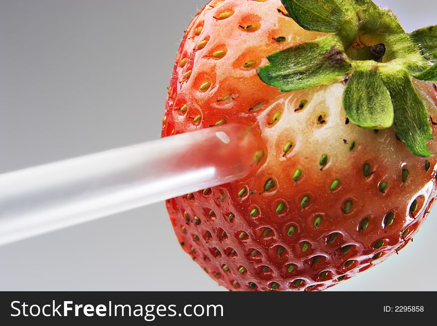 Strawberry with a straw stuck in it. Strawberry with a straw stuck in it