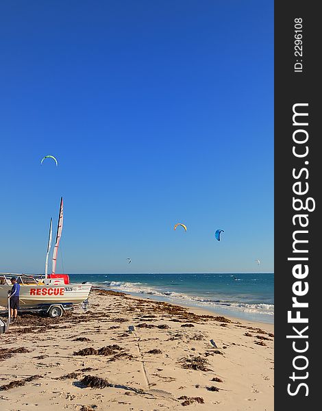 Rescue boat on kite surf beach with kites in the background. Rescue boat on kite surf beach with kites in the background