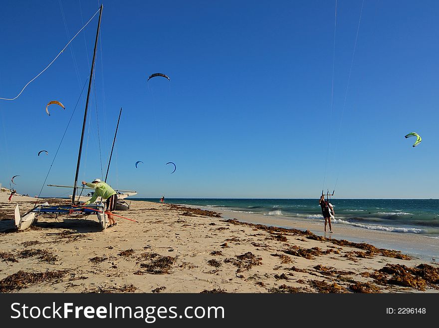 Lots of airborne surf kites with sailing catermaran. Lots of airborne surf kites with sailing catermaran