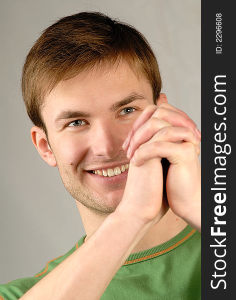 Portrait of  smiling young guy and  compressed hands,  close up. Portrait of  smiling young guy and  compressed hands,  close up