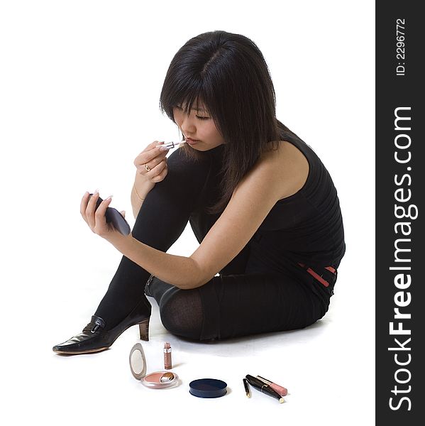 An asian girl doing her make-up. An asian girl doing her make-up