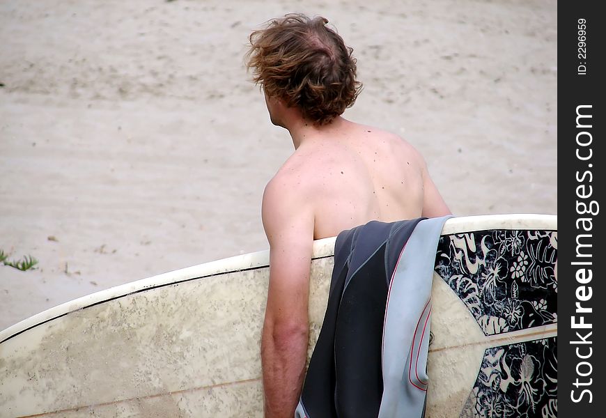 A surfer makes his way down the beach in Malibu, CA. A surfer makes his way down the beach in Malibu, CA.