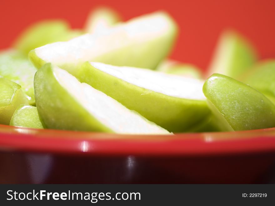 Juicy Sliced Apples against Red background.