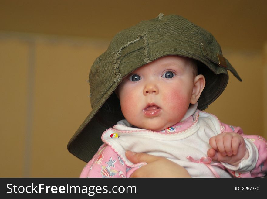 A litle baby in a big cap. A litle baby in a big cap