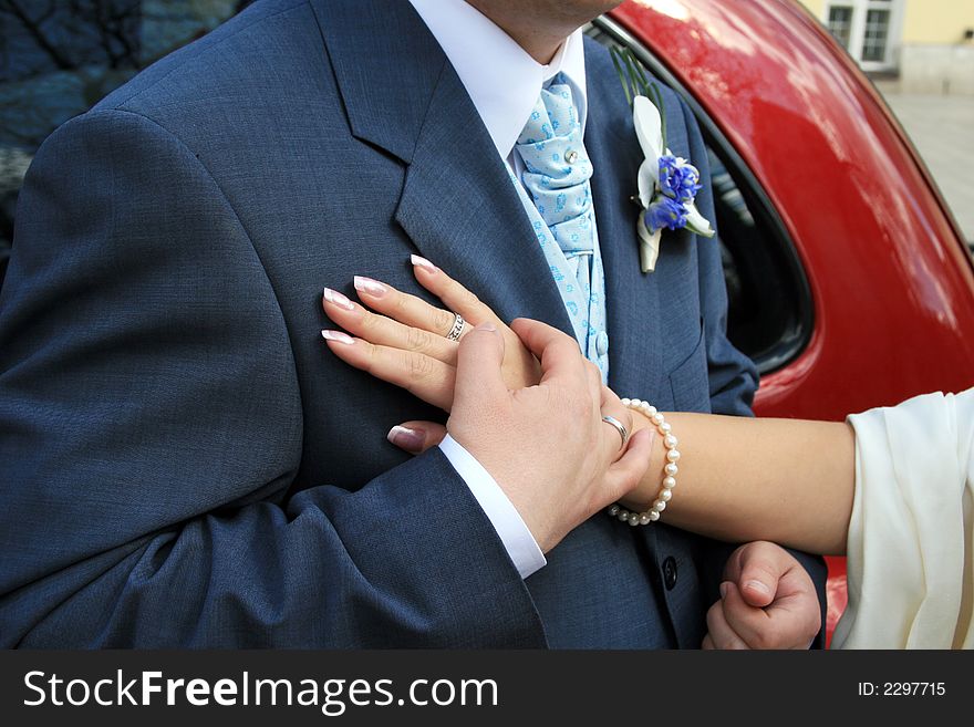 The hands of the bride and the groom on his heart. The hands of the bride and the groom on his heart