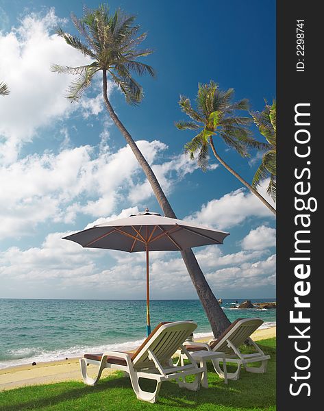 View of two chairs and  white umbrella on the beach  in the morning