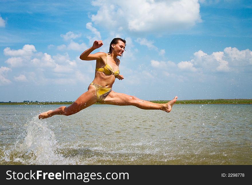 Teen girl in bikini jumping high above the lake. Teen girl in bikini jumping high above the lake