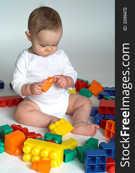 Image of cute baby playing with colorful building blocks. Image of cute baby playing with colorful building blocks