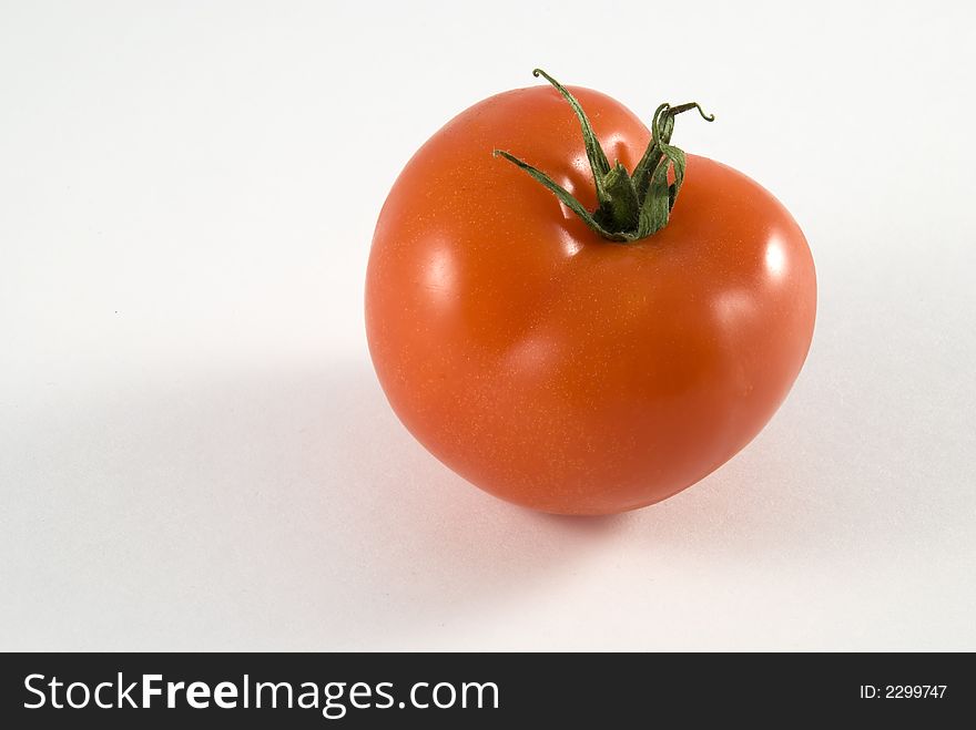 Single red tomato isolated on white background.