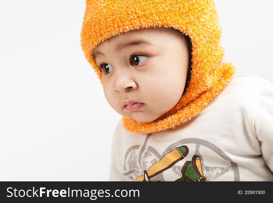Indian curious  boy baby in cap looking at the camera on white background.