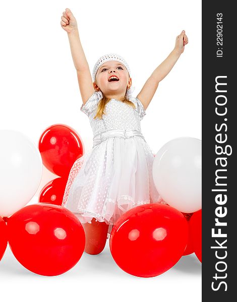 Happy little girl with hands up next to balloons, laughing and waving