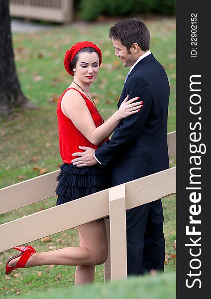 A portrait of a sweet, happy couple with their arms around each other in a lovely outdoor setting. A portrait of a sweet, happy couple with their arms around each other in a lovely outdoor setting