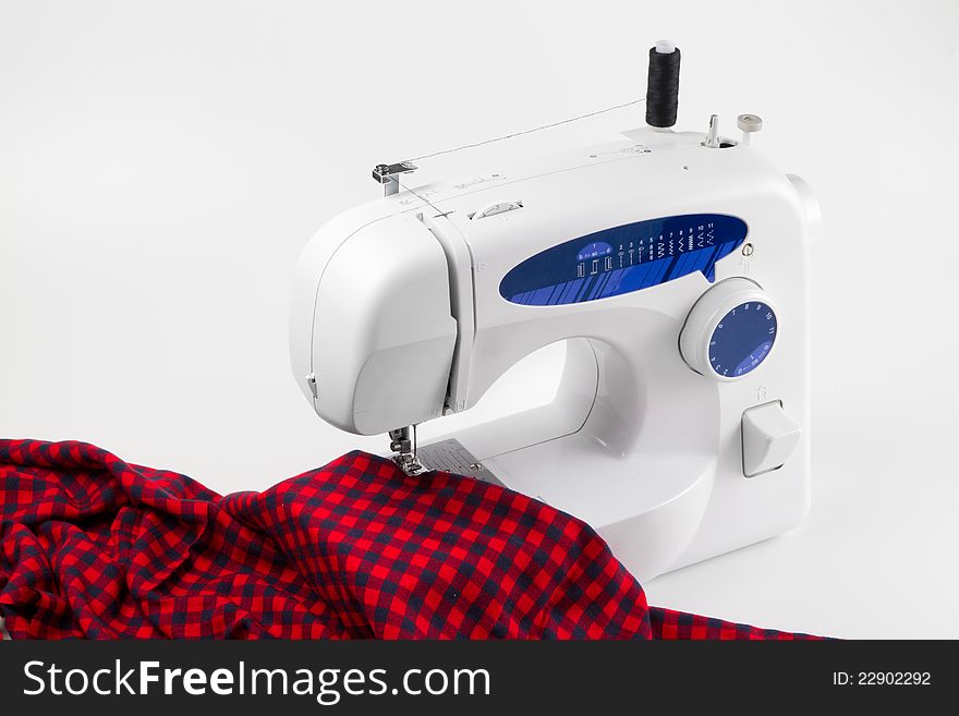 Sewing machine with red cloth on white