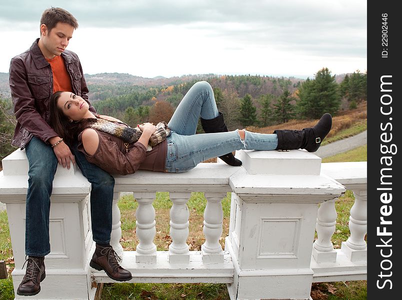 A portrait of a cute couple, relaxing together with mountains in behind them. A portrait of a cute couple, relaxing together with mountains in behind them