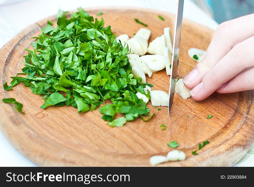 Female chopping food ingredients on wooden board. Female chopping food ingredients on wooden board