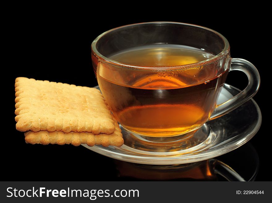 Cup of tea with biscuits on black background