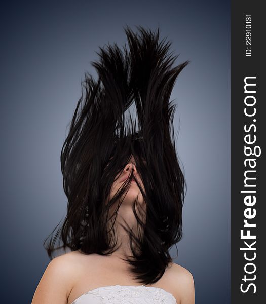 Beautiful girl with fluttering hair on dark background